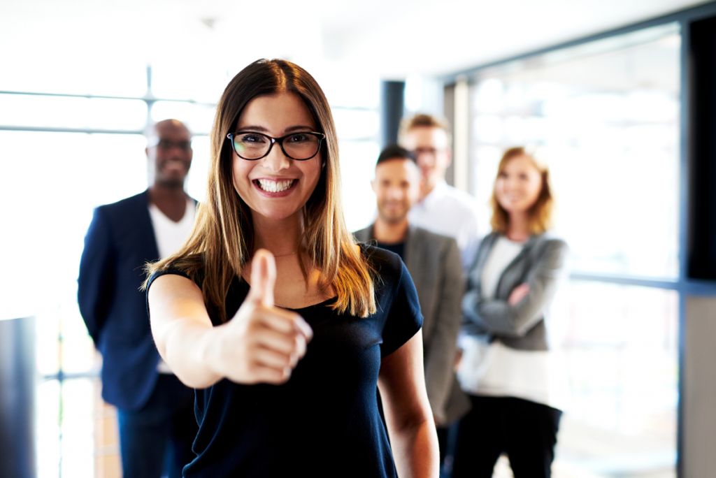 Professionals pausing together in an office (stretching, chatting, relaxing) to support mental health and wellbeing at work.