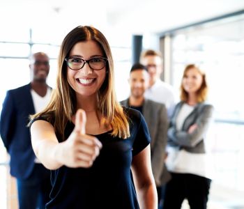 Professionals pausing together in an office (stretching, chatting, relaxing) to support mental health and wellbeing at work.