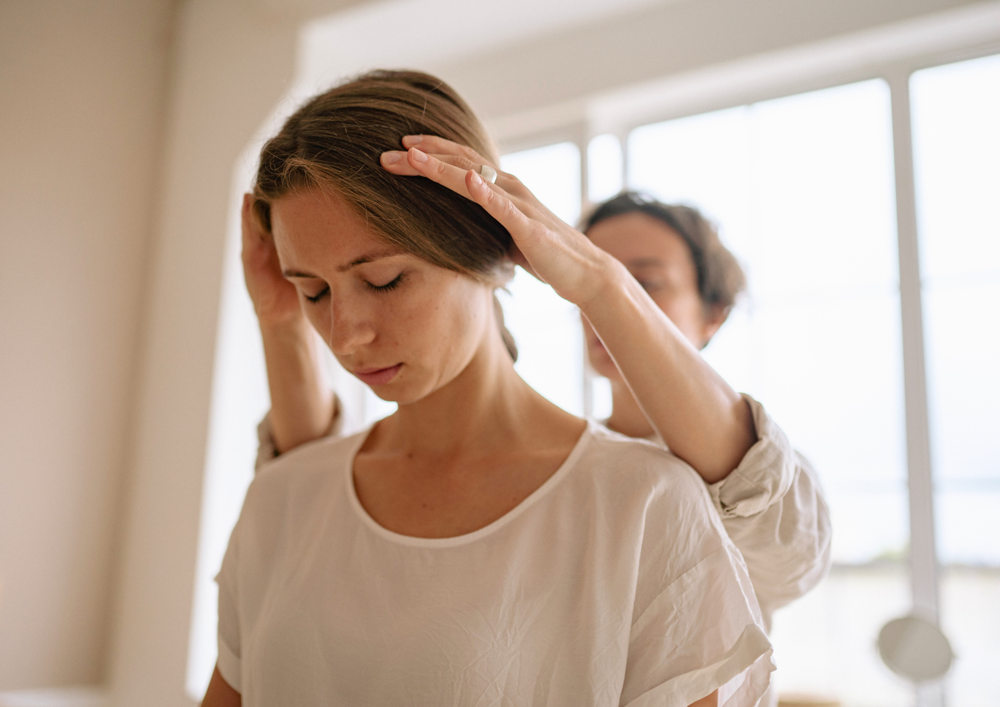 Therapist performing an Indian head massage on an office employee seated in a chair