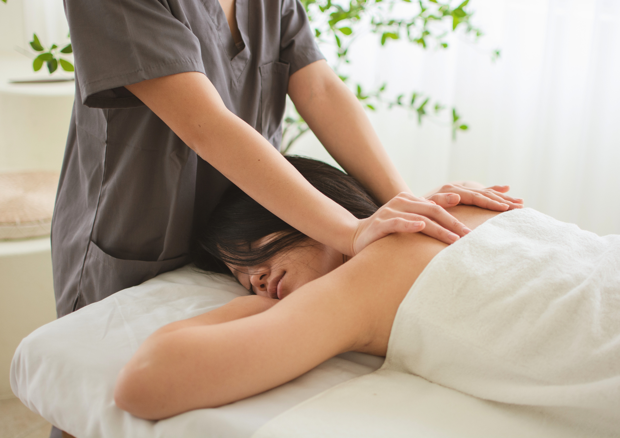 Therapist delivering a deep tissue massage on a couch to an employee in a quiet office space