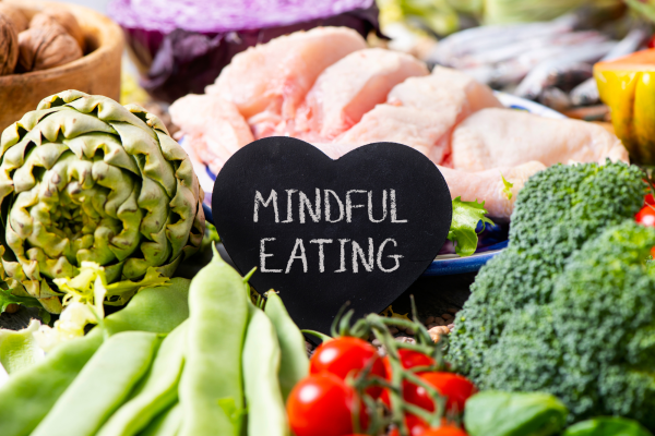 A plate of healthy food with a heart shaped blackboard and the words Mindful Eating