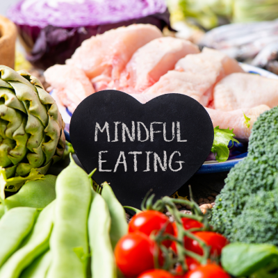 A plate of healthy food with a heart shaped blackboard and the words Mindful Eating