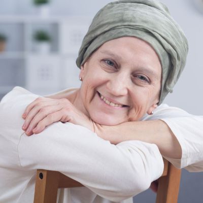 resilient looking mid-life lady smiling and wearing a headscarf
