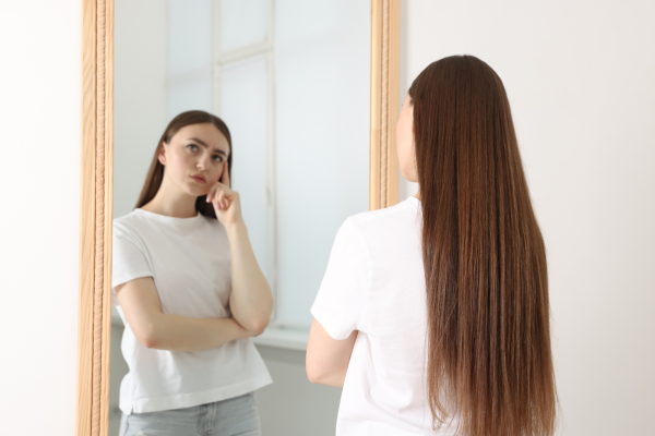 young-woman-looking-in-mirror-suggesting-inner-dialogue-is-occuring